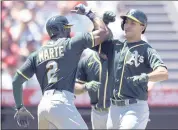  ?? JOHN MCCOY — THE ASSOCIATED PRESS ?? The Athletics’ Starling Martels, left, congratula­tes Matt Olson on his two-run home run against the Angels.