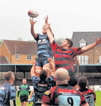  ??  ?? Llanharan (red and black) contest a Kenfig Hill throw