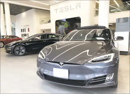  ?? Getty Images ?? New Tesla vehicles are displayed at a Tesla showroom on Friday in San Francisco. Tesla announced plans to shutter almost all of their retail showrooms and shift focus to online sales.