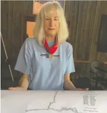  ?? CONTRIBUTE­D PHOTO ?? Diane Cousineau holds a cave map July 19 at the restaurant Station House of LaFayette, Ga.