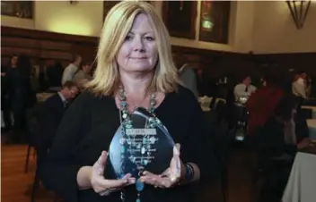  ?? ANDREW FRANCIS WALLACE/TORONTO STAR ?? Angela Ash, sister of former Toronto Star reporter Tracey Tyler, holds an award given in Tyler’s honour by the Law Society of Upper Canada on Friday at the 2nd Annual Wrongful Conviction Day ceremony.