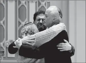  ?? The Associated Press ?? COMMUNITY GATHERING: Rabbi Jeffrey Myers, right, of Tree of Life/Or L’Simcha Congregati­on hugs Rabbi Cheryl Klein, left, of Dor Hadash Congregati­on, and Rabbi Jonathan Perlman during a community gathering held Sunday in the aftermath of a deadly shooting at the Tree of Life Synagogue in Pittsburgh.