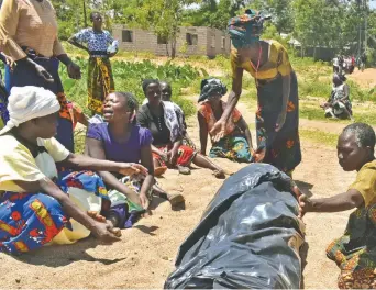  ??  ?? Mujeres lloran junto al cadáver de un familiar, víctima del hundimient­o del ferry de pasajeros MV Nyerere, mientras esperan el transporte para su entierro en la isla de Ukara, Tanzania.