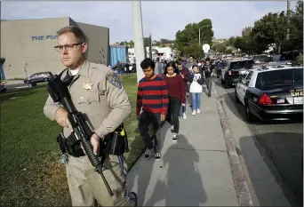  ?? MARCIO JOSE SANCHEZ — THE ASSOCIATED PRESS ?? A police officer escorts students out of Saugus High School after reports of a shooting on Thursday in Santa Clarita.