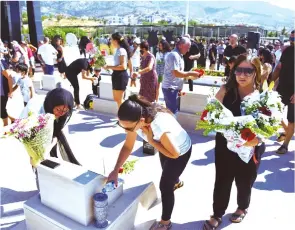  ?? ?? Mourners laying flowers at the graves of their loved ones at the Taşkent Martyrs Cemetery