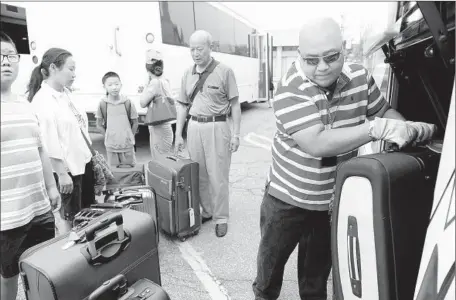  ?? Photograph­s by
Christina House
For The Times ?? DRIVER Ramoncito Batac helps load luggage onto a bus taking travelers on a seven-day trip to Yellowston­e National Park and Mt. Rushmore from America Asia Travel Center in Monterey Park. Tourism businesses braced for a slowdown, but it’s been a no-show...