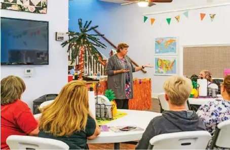  ??  ?? Missouri Star Quilt Co. founder Jenny Doan (right) leads a quilting class at the center. Quilters come for the classes and the themed stores (above).