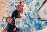  ??  ?? Waste flow:
Chrissie Cleary and Marc Lenton with their creation, Waterfall,
made of plastic bottles.