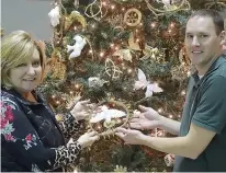 ?? Staff photo by Neil Abeles ?? Marilyn Cobb and Jacob Smith, pastor of Atlanta First United Methodist Church, show off the Pure Pelican, one of the highly detailed Christmas tree ornaments called a Chrismon, which was handmade, perhaps 30 years ago, by church members.