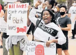  ?? STEPHEN M. DOWELL/ORLANDO SENTINEL ?? Protesters chant in front of City Hall in Orlando Sunday while holding signs in support of Black Lives Matter. Organizers highlighte­d local black business owners to the crowd.