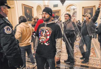  ?? Manuel Balce Ceneta The Associated Press ?? Rioters are confronted by U.S. Capitol Police officers outside the Senate chamber inside the Capitol on Jan. 6, 2021. Fox News’ Tucker Carlson has aired select footage.