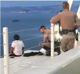  ?? California Highway Patrol ?? Officer Jeremy Maya ( center) coaxed the woman to safety from her precarious perch.