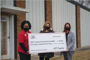  ?? Staff photo by Kelsi Brinkmeyer ?? From left, Marcia Austin, Jennifer Harland and Jennifer Lewis hold a grant check presented Tuesday to Texarkana Resources for the Disabled by American Electric Power Foundation outside of the building they will renovate with the grant money.