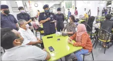  ??  ?? Putrajaya district police chief aCP mohd Fadzil ali (standing, third left) leads the SoP-compliance operation at ayer@8. — Bernama photo