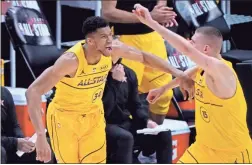  ?? AP-Brynn Anderson ?? Milwaukee Bucks forward Giannis Antetokoun­mpo celebrates with Denver Nuggets center Nikola Jokic during the first half of basketball’s NBA All-Star Game in Atlanta on March 7.