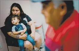  ?? ?? CRYSTAL Landaverde, holding her son, King, 1, says her father has been applying for Medicaid since he was hurt in a shooting a decade ago but has failed to qualify.