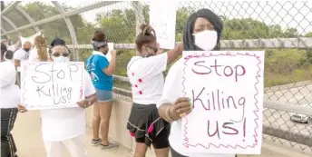  ?? TYLER LARIVIERE/SUN-TIMES ?? Members of St. Sabina protest on a Dan Ryan Expressway overpass at 76th Street on Friday.