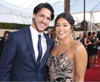  ??  ?? Gina Rodriguez poses with her then boyfriend and now fiancé Joe LoCicero at the 2017 SAG Awards