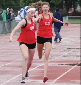  ?? MIKE BUSH/NEWS-SENTINEL ?? Above: Lodi's Brooke Aberle, left, takes the baton from Amelia Ellison in the girls' 4-by-400 relay at the Sac-Joaquin Section Masters at Davis High on May 18. Below: Tokay's Kari Anema, center, and the rest of the girls competing in the 800-meter race.