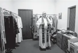  ?? Jon Shapley / Houston Chronicle ?? Keith Giblin, a magistrate judge and Episcopal priest, dons his vestments before a service at St. Paul’s Episcopal Church in Orange.