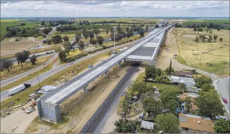  ?? Robert Gauthier Los Angeles Times ?? NEW LAND requiremen­ts complicate efforts by rail authority leaders to turn around years of delays, cost overruns and technical problems that are threatenin­g political support for the bullet train project. Above, constructi­on on the San Joaquin River Viaduct in Fresno.