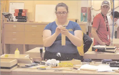  ??  ?? Adelaide Buck, a student from Brooks Composite High School, works on building a tee box at the Regional Skills Competitio­n April 30.