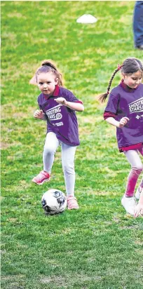  ??  ?? Park life: Kate, the Duchess of Cambridge, has a kickabout at Windsor Park, Belfast; (below) she and Prince William meet goalkeepin­g legend Pat Jennings