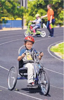  ?? JIM THOMPSON/JOURNAL ?? Gabbon, 9, races around a turn on the La Cueva High School track this week during Carrie Tingley Hospital Foundation’s Camp Adventure.