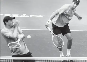  ?? MARK WEBER/THE COMMERCIAL APPEAL ?? American Bob Bryan (left) takes a shot from brother and doubles teammate Mike Bryan during their first-round Memphis Open match Tuesday at The Racquet Club. The top-seeded Bryans lost to fellow Americans Austin Krajicek and Nicholas Monroe 1-6, 7-6 (5), 12-10.