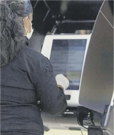  ??  ?? 0 A Woman uses electronic voting machine at a polling station in Washington, DC, during early voting