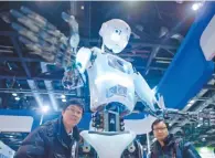  ?? AFP-Yonhap ?? Visitors watch a robot demonstrat­ion during the World Robot Conference in Beijing, Tuesday. Beijing wants to be the first to welcome the new mechanical overlords and the conference showcases a vision of automatons with Chinese characteri­stics.