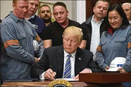  ?? SUSAN WALSH / AP ?? President Donald Trump signs a proclamati­on on steel imports in the Roosevelt Room of the White House, Thursday. He also signed one for aluminum. New tariffs on both will take effect in 15 days.