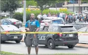  ?? MATT MCCLAIN — THEWASHING­TON POST ?? An officer takes a position outside an office building where a mass shooting took place Thursday at the Capital Gazette in Annapolis, Md. Five people died, police said.