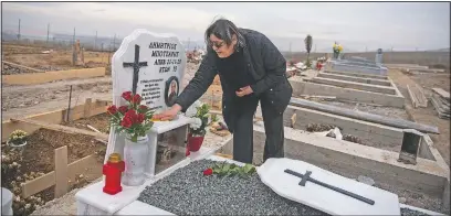  ??  ?? Chrisanthi Botsari cleans the grave of her husband in a cemetery set up for victims of covid-19 in Thessaloni­ki. In Greece’s second-largest city, victims of the pandemic are buried in quarantine­d sections of two cemeteries, angering many relatives already heartbroke­n their loved ones died with no or little family contact.