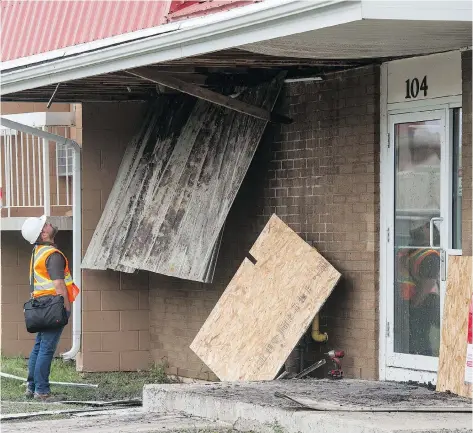  ?? BRANDON HARDER ?? An investigat­or examines damage caused to an apartment building on Hanbidge Cres., which was affected by fire on Saturday night.