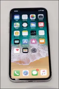  ?? The Associated Press ?? iPHONE X: The new iPhone X is displayed in the showroom after Apple’s new product announceme­nt Tuesday at the Steve Jobs Theater on the new Apple campus in Cupertino, Calif.