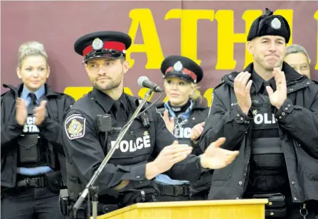  ?? JASON BAIN/ EXAMINER ?? City police community service officers and emcees Const. Grant Eastwood and Const. Andy Hatton applaud during a formal announceme­nt Wednesday at St. Peter Secondary School that the city will host the 2018 Special Olympics School Championsh­ips in May....