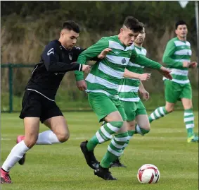  ??  ?? Jamie Spillane, Killarney Celtic, looks to break away from Dion Catan, Rineanna Rovers, in the FAI Junior Cup at Celtic Park. Photos by Michelle Cooper Galvin