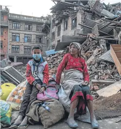  ??  ?? Two people sit with their belongings amid the rubble in Kathmandu, while members of the Nepalese community in Perth gather for a minute’s silence, followed by fundraisin­g, for the victims of the earthquake. Prabina Khanal, left, and her sister Rubina...