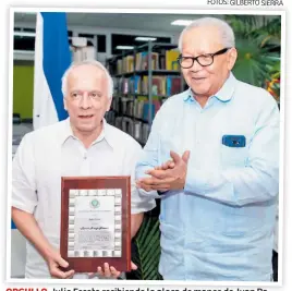  ?? FOTOS: GILBERTO SIERRA ?? ORGULLO. Julio Escoto recibiendo la placa de manos de Juan Ramón Martínez