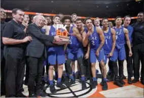  ?? CRAIG MITCHELLDY­ER — THE ASSOCIATED PRESS ?? Nike founder Phil Knight presents the championsh­ip trophy to Duke head coach Mike Krzyzewski, left, after an NCAA college basketball game against Florida in the Phil Knight Invitation­al tournament in Portland, Ore., Sunday. Duke won 87-84.