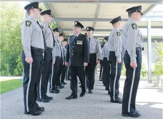  ?? GAVIN YOUNG/ CALGARY HERALD ?? Brian Whitelaw, co- ordinator for public safety with Calgary Transit, leads an inspection of 13 new peace officers before their graduation ceremony at Fort Calgary on Thursday.