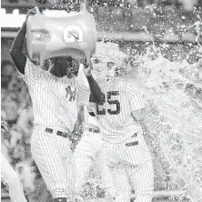  ?? Frank Franklin II / Associated Press ?? The Yankees' Didi Gregorius gives Gleyber Torres a wet welcome after Torres’ game-winning RBI single in the 10th.