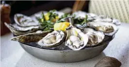  ?? SARAH SWETLIK / FRESH TAKE GEORGIA VIA AP ?? A plate of fresh, raw oysters with lemon and parsley sits on a table at C&S Seafood and Oyster Bar in Georgia. Oysters are versatile in cooking and can be found on menus ranging from raw to roasted and everything in between.