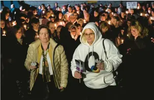  ?? BILL UHRICH/READING EAGLE ?? Michelle Dech, executive director of the LGBT Center, left, and Julia Rump, mother of Derrick Rump, who was killed in the Club Q shooting in Colorado, lead a candleligh­t procession Tuesday.