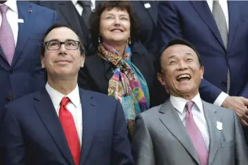  ??  ?? US Treasury Secretary Steve Mnuchin (left) and Japan’s Deputy Prime Minister and Finance Minister Taro Aso participat­e in the Internatio­nal Monetary Fund Governors family photo during the IMF/World Bank spring meeting in Washington. — Reuters photo