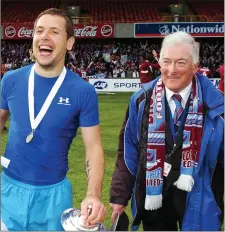  ??  ?? Despite suffering a serious injury earlier in the game, Declan O’Brien sports a broad smile as he parades with the Setanta Cup trophy alongside the late, great club chairman Vincent Hoey.
