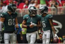  ?? DANNY KARNIK — THE ASSOCIATED PRESS ?? Eagles wide receiver DeVonta Smith, right, quarterbac­k Jalen Hurts, middle, and tight end Dallas Goedert quietly celebrate a touchdown in the first half Sunday at Mercedes Benz Stadium in Atlanta.