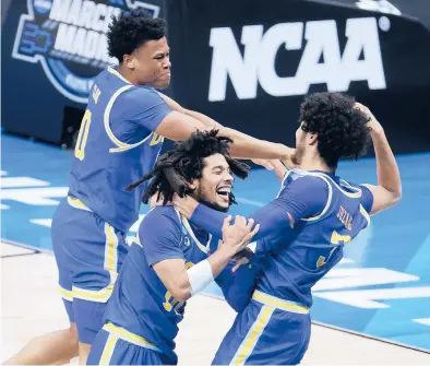  ?? ANDY LYONS/GETTY ?? Jaylen Clark, from left, Tyger Campbell and Johnny Juzang of UCLA celebrate after defeating Michigan 51-49 in the Elite Eight round game of the NCAA Tournament on Tuesday night at Lucas Oil Stadium in Indianapol­is.