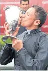  ??  ?? Frankie Dettori kisses the Goodwood Cup after victory on Stradivari­us.